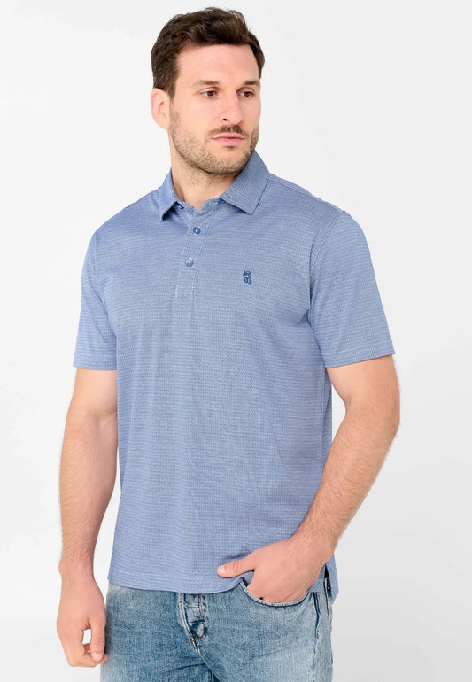 Polo de hombre azul con estampado geométrico fino, cuello clásico, botones y logo bordado, puesto por un modelo.