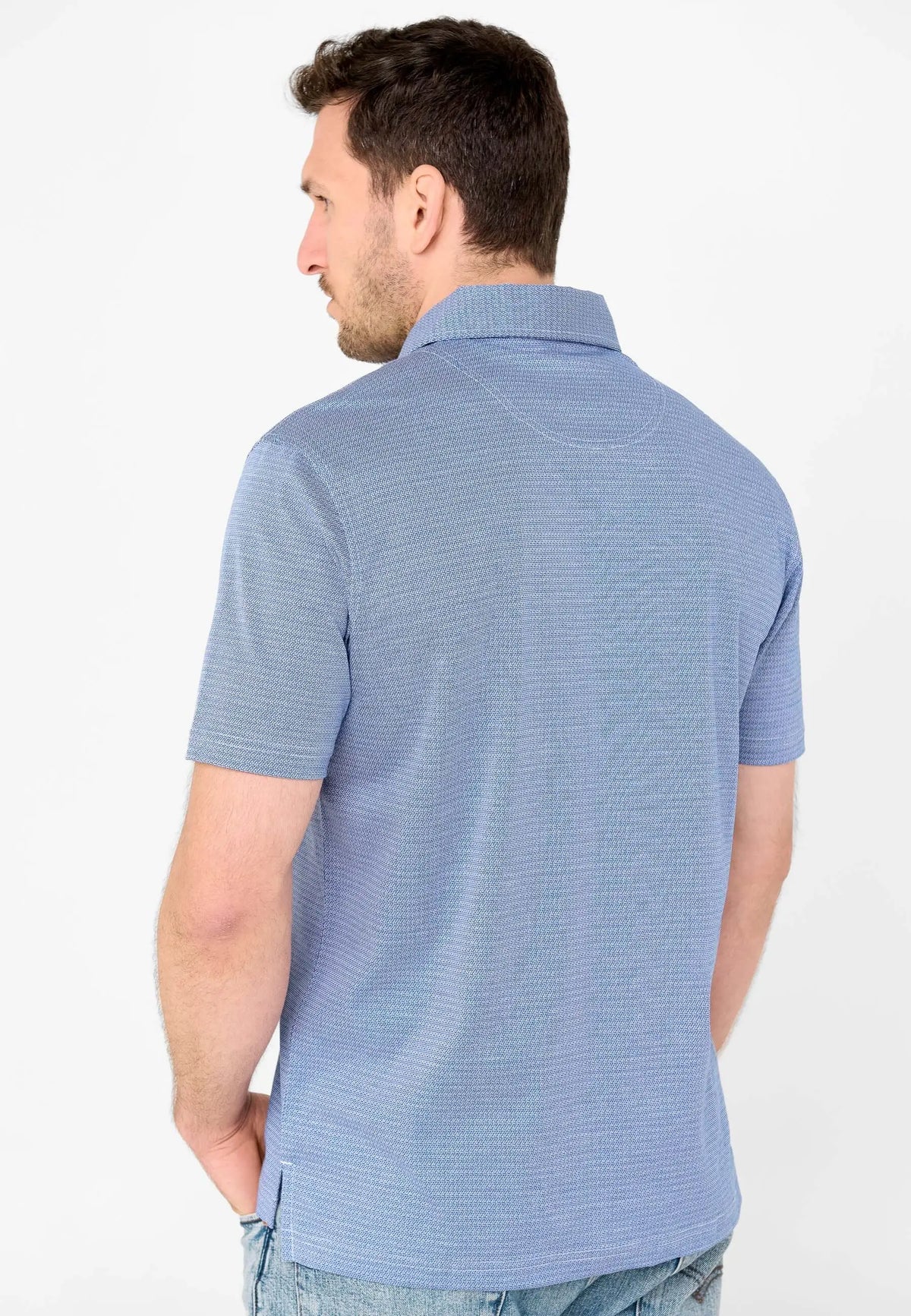 Polo de hombre azul de manga corta, con tejido de textura geométrica fina, visto desde atrás en un modelo.