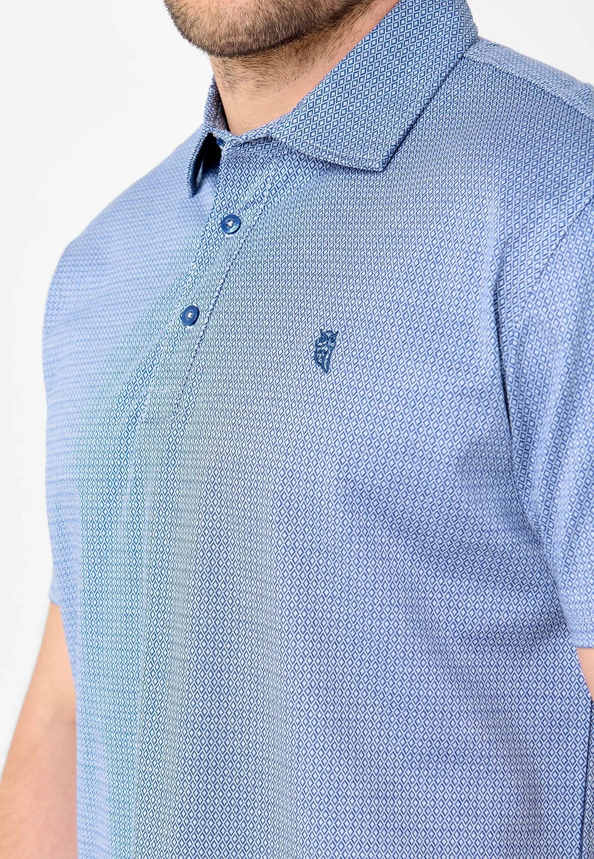 Polo azul de hombre con estampado geométrico de rombos, cuello camisero, dos botones y logo bordado de El Búho Nocturno.