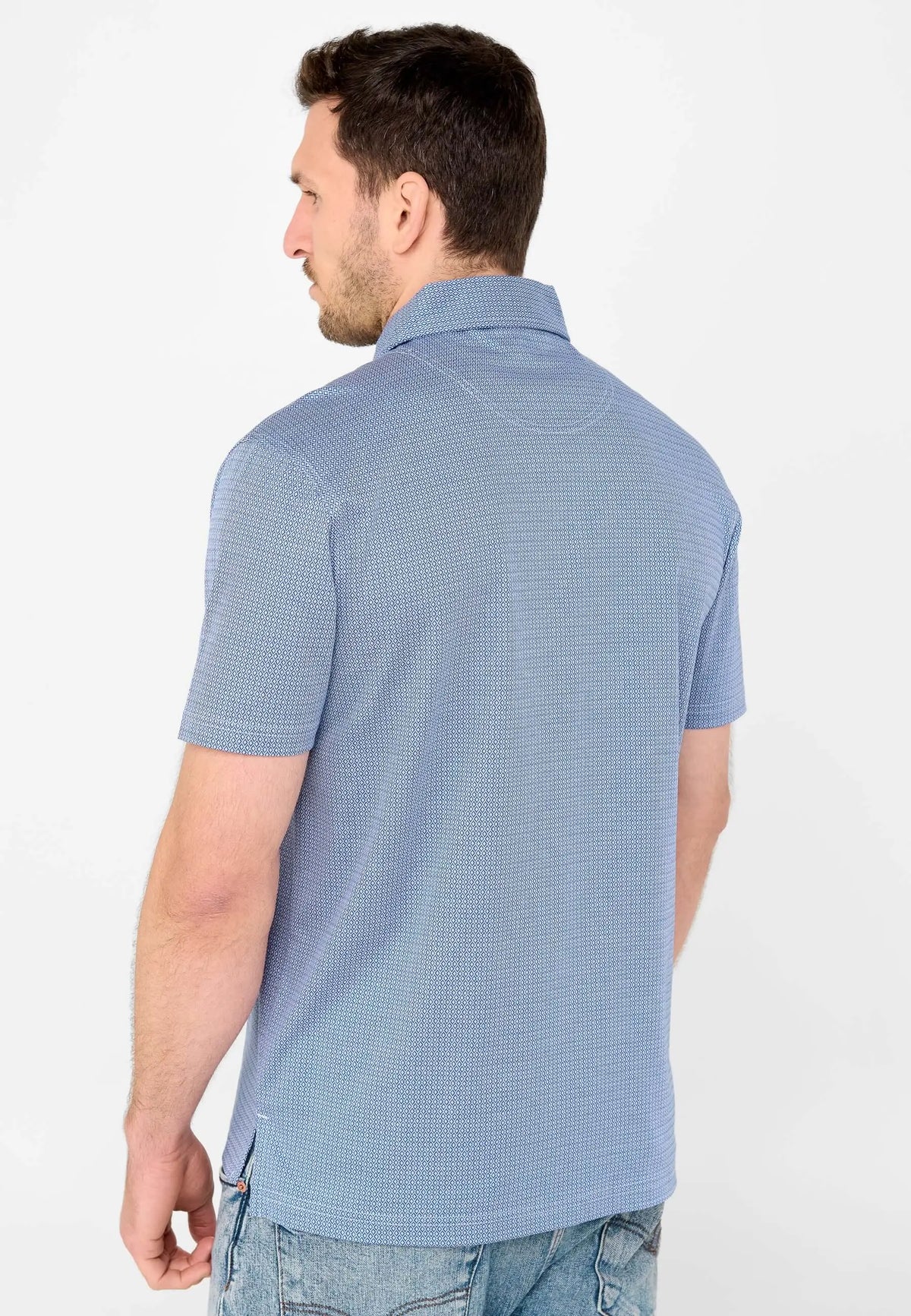 Polo de hombre azul con estampado geométrico pequeño, manga corta y cuello camisero, visto de espaldas en un modelo.