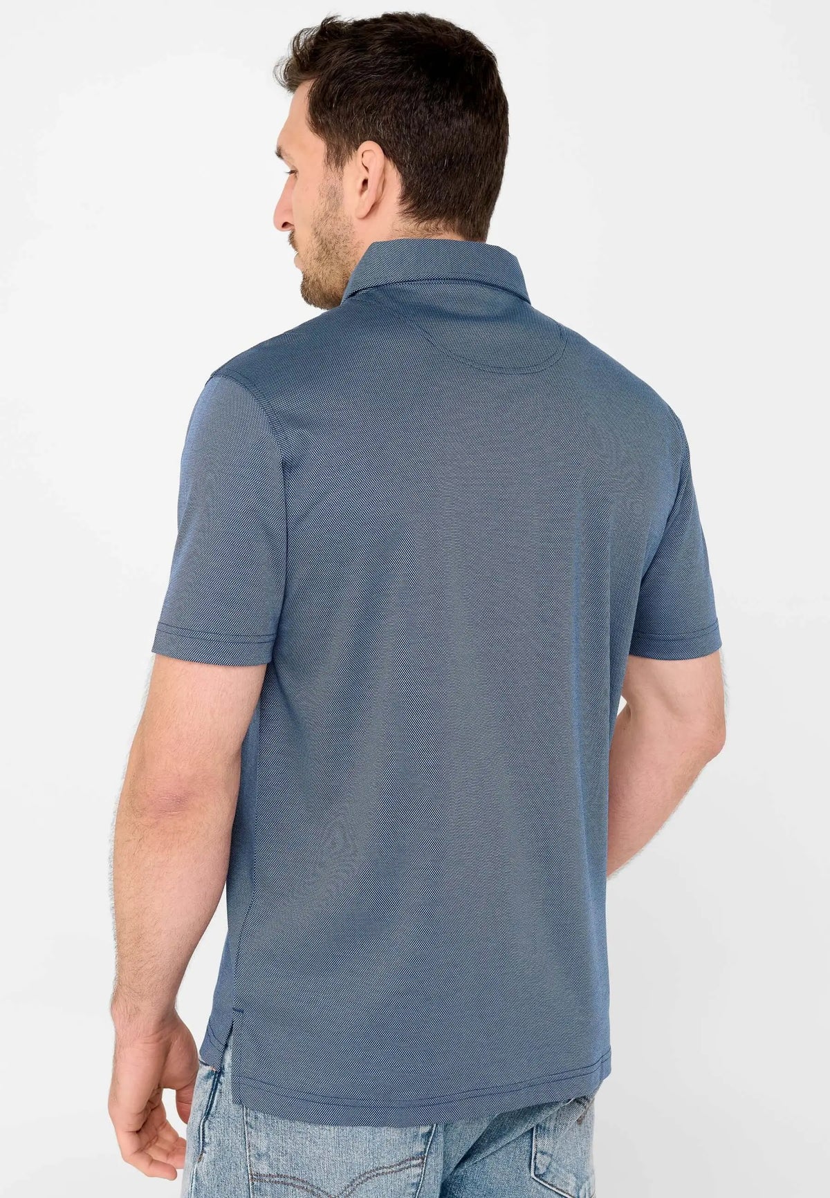 Polo de hombre azul de manga corta, tejido texturizado con cuello, visto desde la espalda sobre fondo blanco.