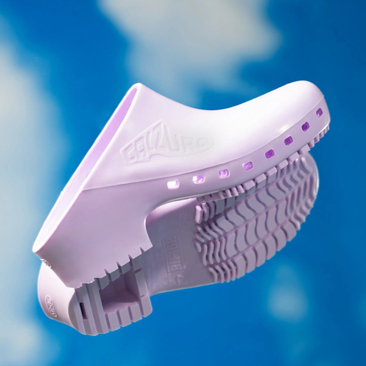 Lavender, hole-free rubber professional clog with a thick, textured anti-slip sole against a blue cloudy background.