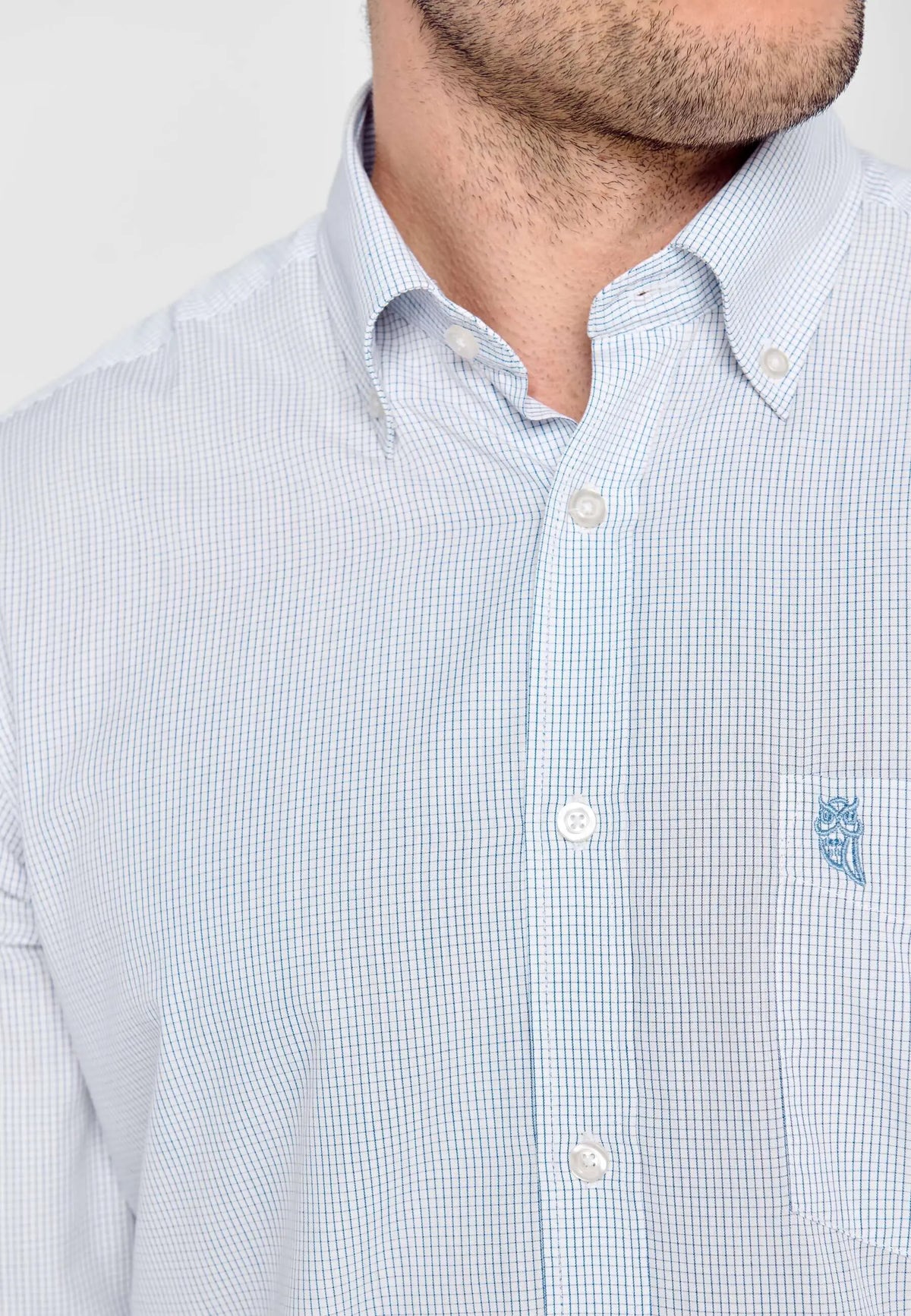 Camisa de hombre de manga larga en popelín azul con cuadros pequeños, cuello abotonado y bolsillo en el pecho.