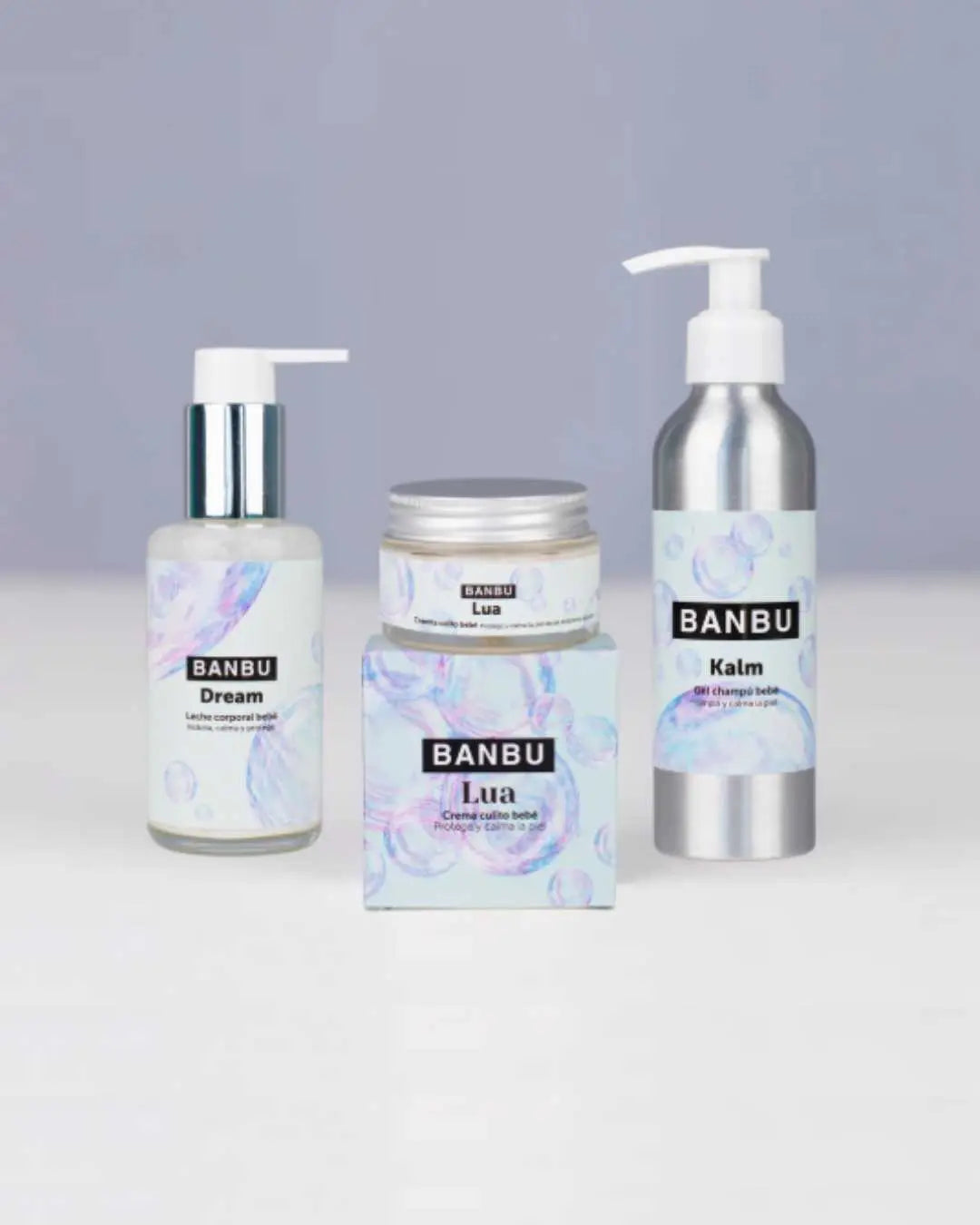 Pack de cosmética infantil Banbu con dos botes de aluminio con dosificador y una crema sobre fondo gris claro.