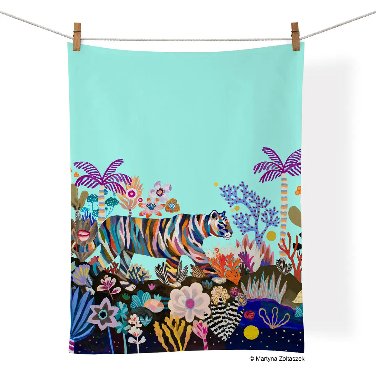 Cotton tea towel with a striped tiger walking through a colorful, vibrant, whimsical jungle on a light blue background.