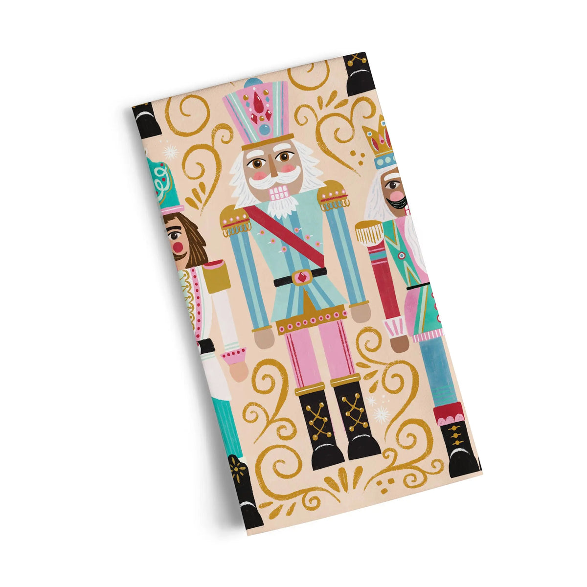 Cotton tea towel with a light tan background, decorated with illustrated nutcrackers and gold swirling patterns.
