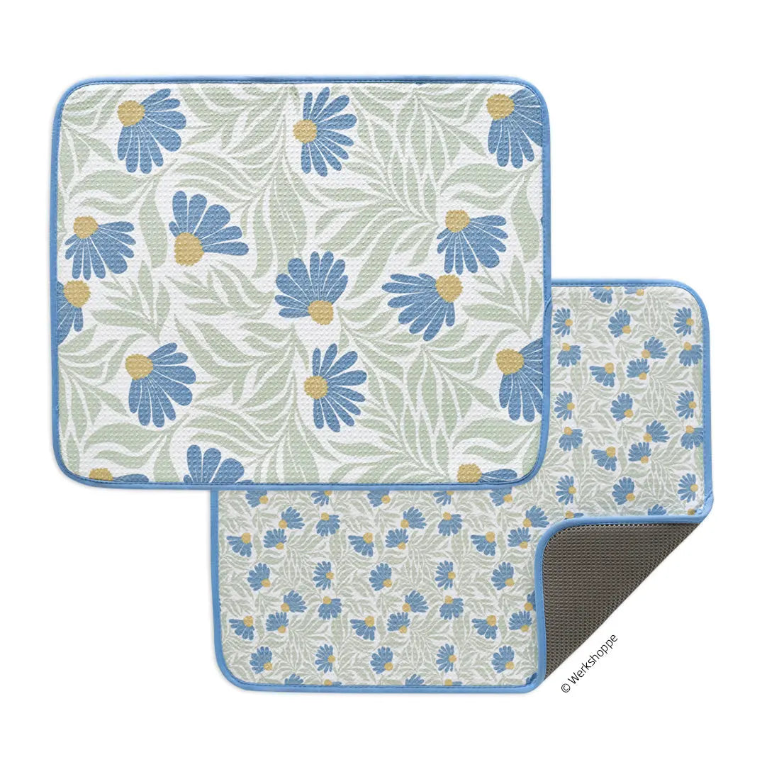 Two rectangular dish drying mats with a blue coneflower and sage green leaf pattern and a textured grey backing.
