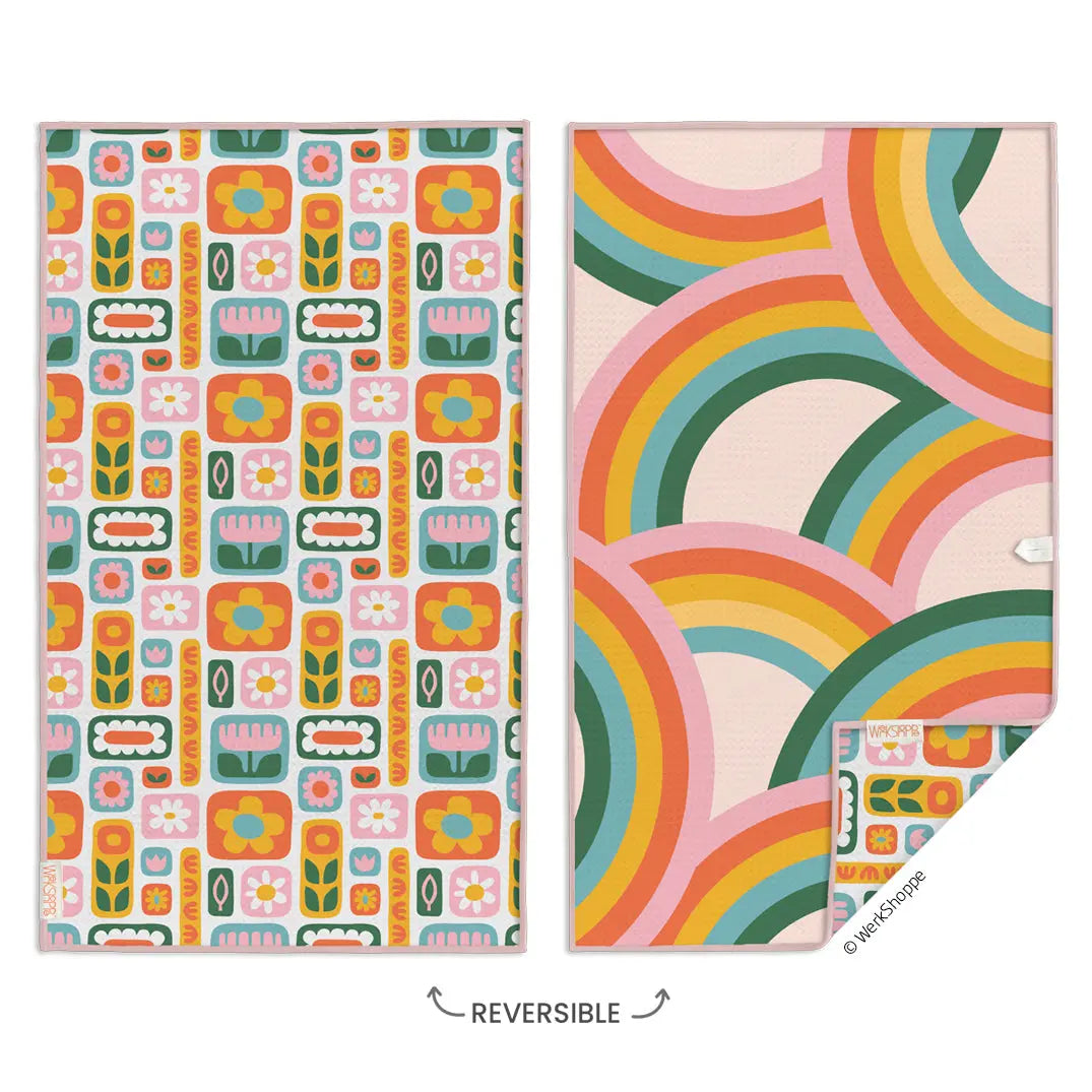 Reversible microfiber towel featuring a retro daisy and floral pattern on one side and colorful rainbows on the other.