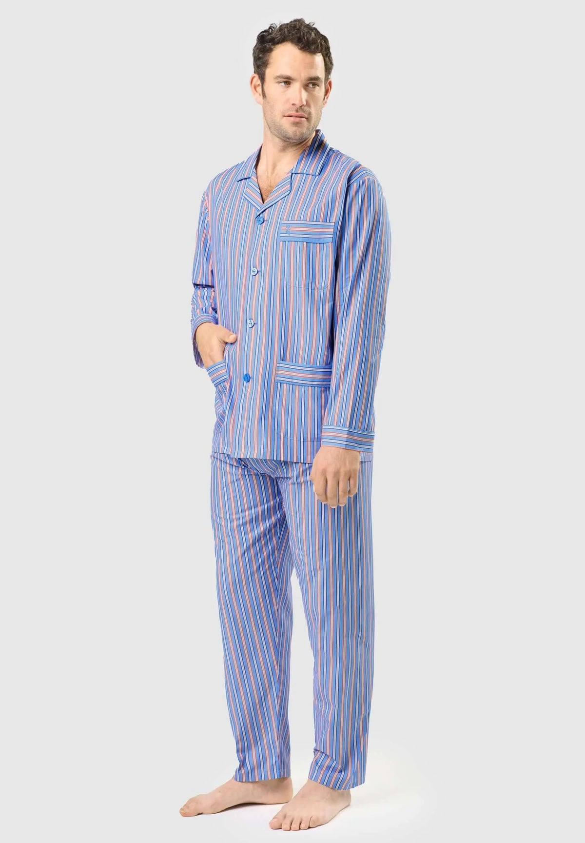 Pijama de hombre azul a rayas con solapa, botones, bolsillos y tejido de algodón fino, puesto por un modelo.