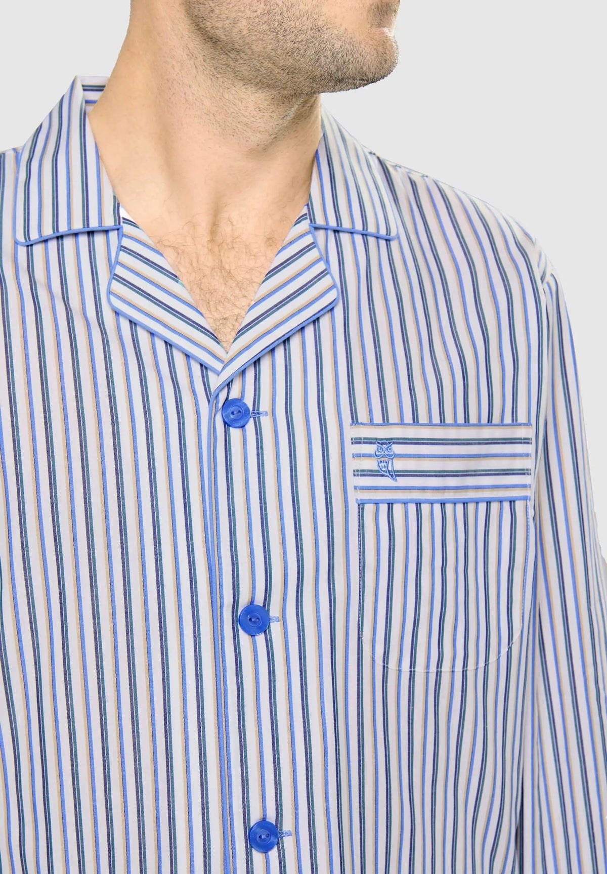 Pijama de hombre con solapas, estampado de rayas azules y beige, botones azules y bolsillo con logo bordado en el pecho.