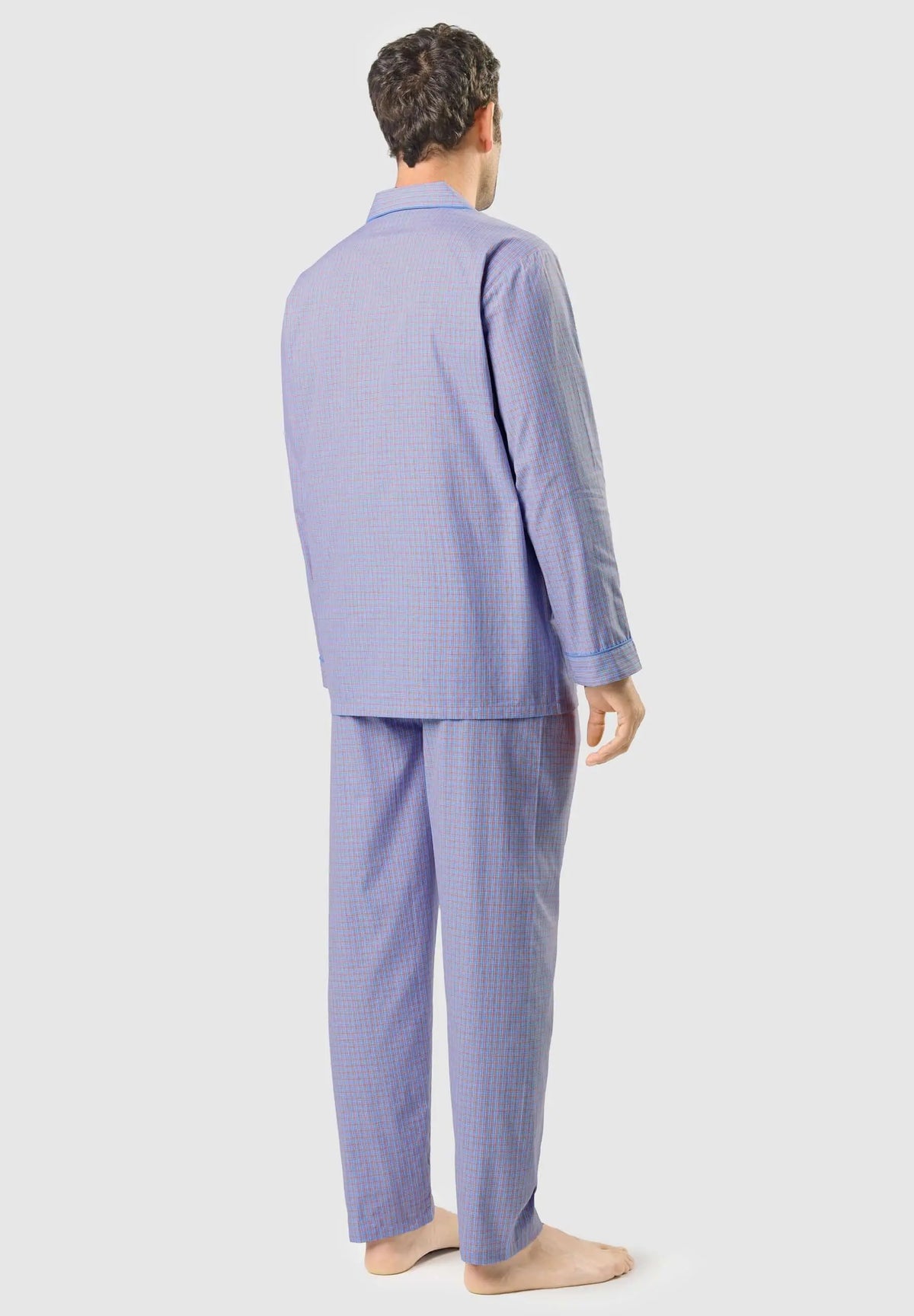 Pijama largo de hombre azul con estampado de cuadros pequeños, modelo de espaldas con cuello de solapa y ribete azul.