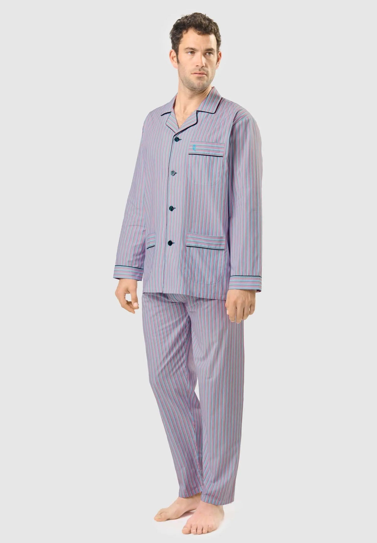 Hombre viste pijama largo de algodón con rayas verticales, cuello solapa, botones y bolsillos, en tonos azul y granate.