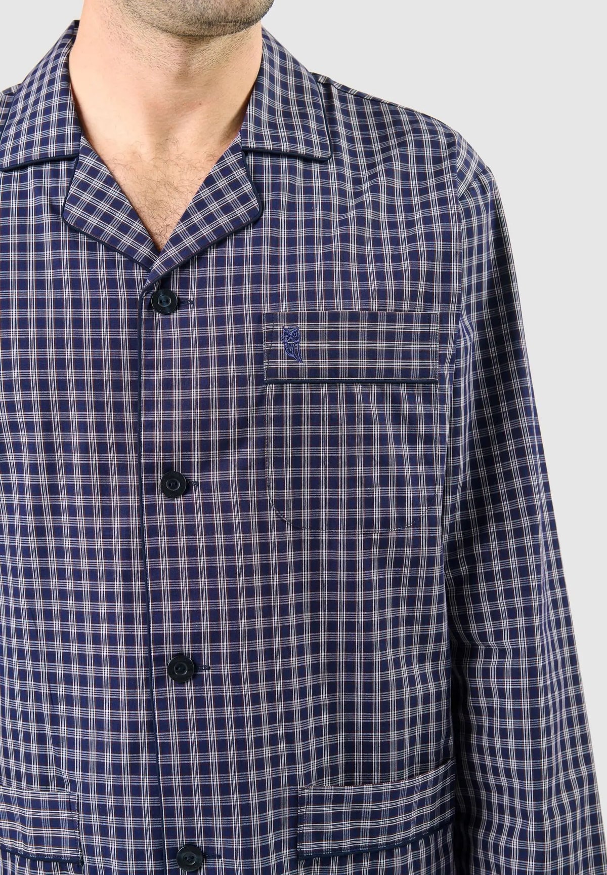 Pijama de hombre azul a cuadros con solapa, botones, bolsillo frontal con logo bordado de búho y tejido fino.