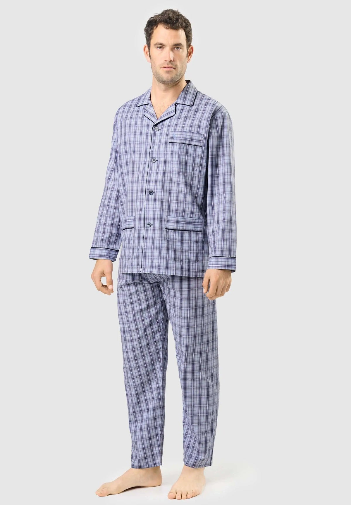 Hombre con pijama largo de cuadros azules, camisa de solapa con botones y bolsillos, tejido liso y estilo clásico.