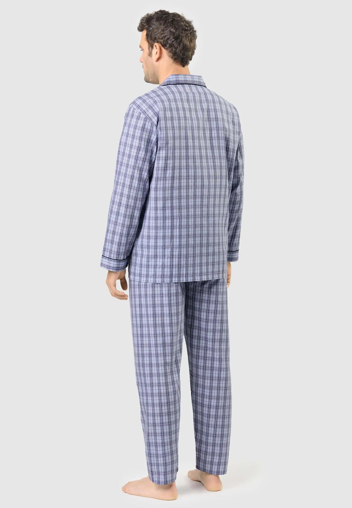 Hombre de espaldas vistiendo pijama largo de cuadros azules con solapa, tejido fino y detalles en ribete oscuro.