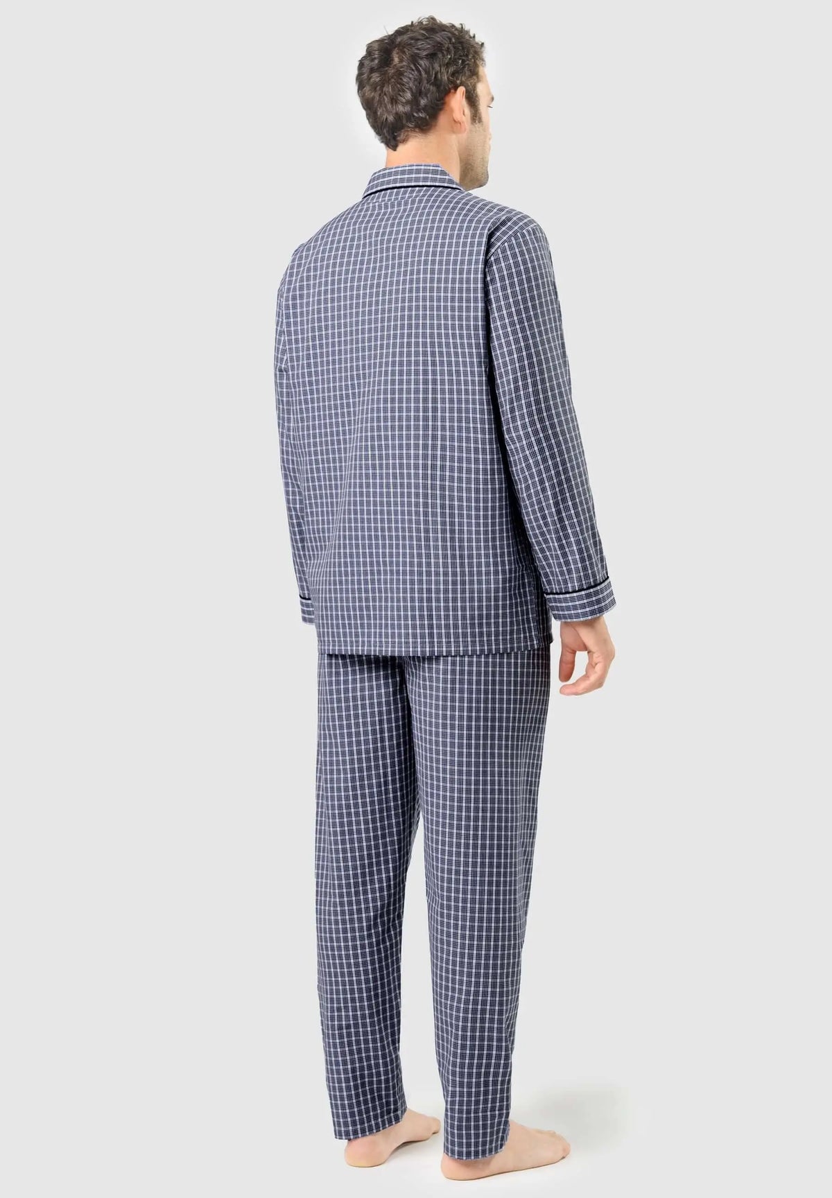 Pijama largo de hombre azul a cuadros con solapa, visto de espaldas sobre modelo. Estilo clásico de tela estructurada.