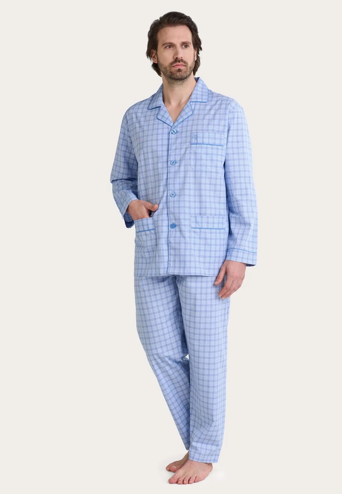 Pijama de hombre azul a cuadros, camisa de manga larga con solapas, botones y bolsillo, pantalón a juego.