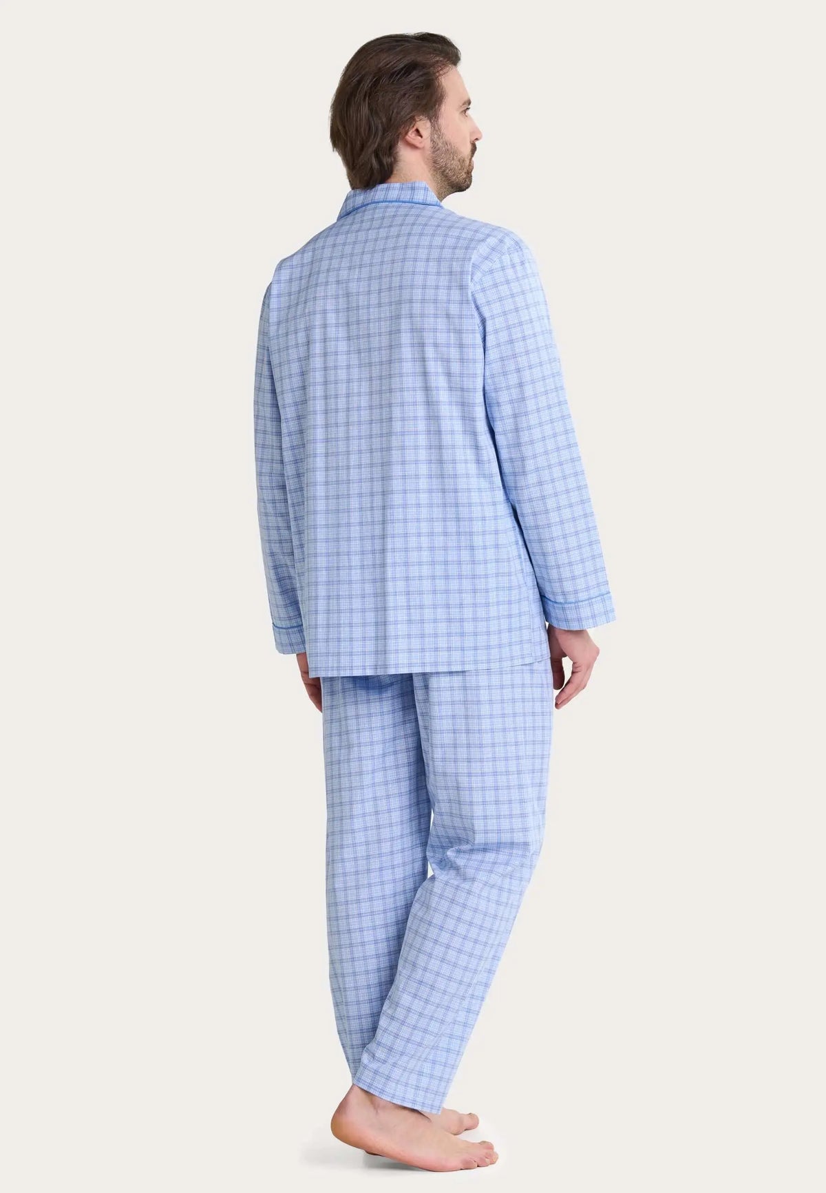 Hombre con pijama largo de tela azul con estampado de cuadros, de manga larga y cuello solapa.