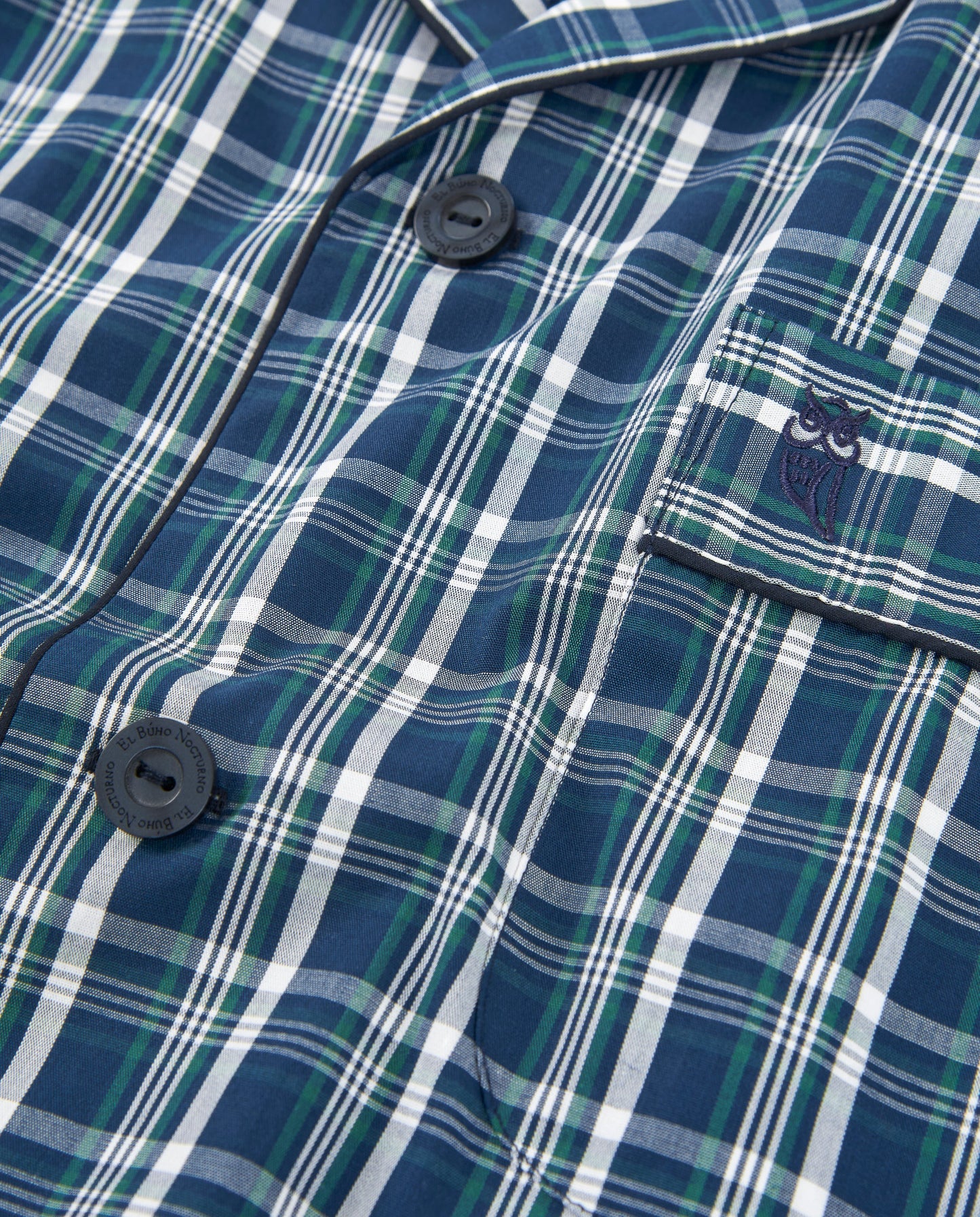 Camisa de pijama de cuadros azul marino, verde y blanco, con bolsillo y botones en material suave.