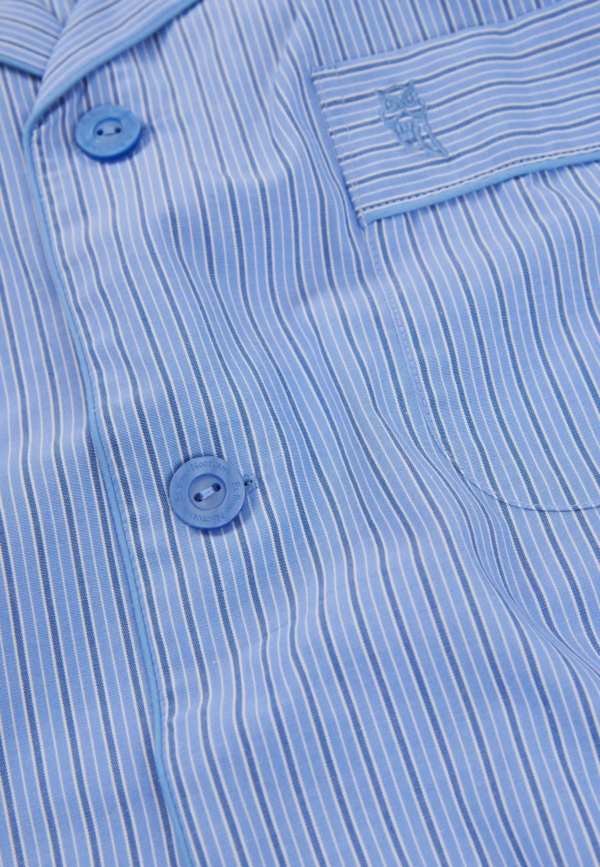 Camisa de pijama azul a rayas, 100% algodón, con botones y bolsillo frontal bordado.