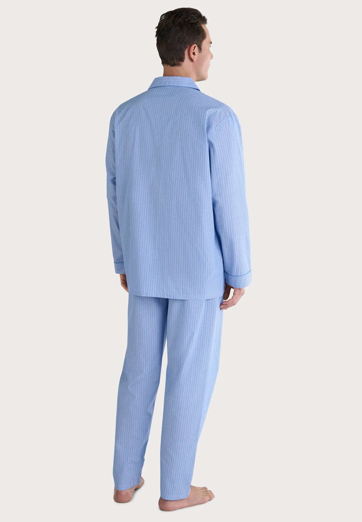 Pijama de hombre rayado azul claro, de algodón suave, estilo clásico con camisa de botones y pantalones cómodos.