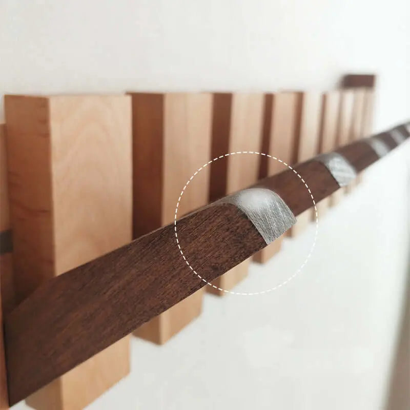 Perchero de pared estilo nórdico, con listones de madera clara y barra abatible oscura con detalles metálicos.