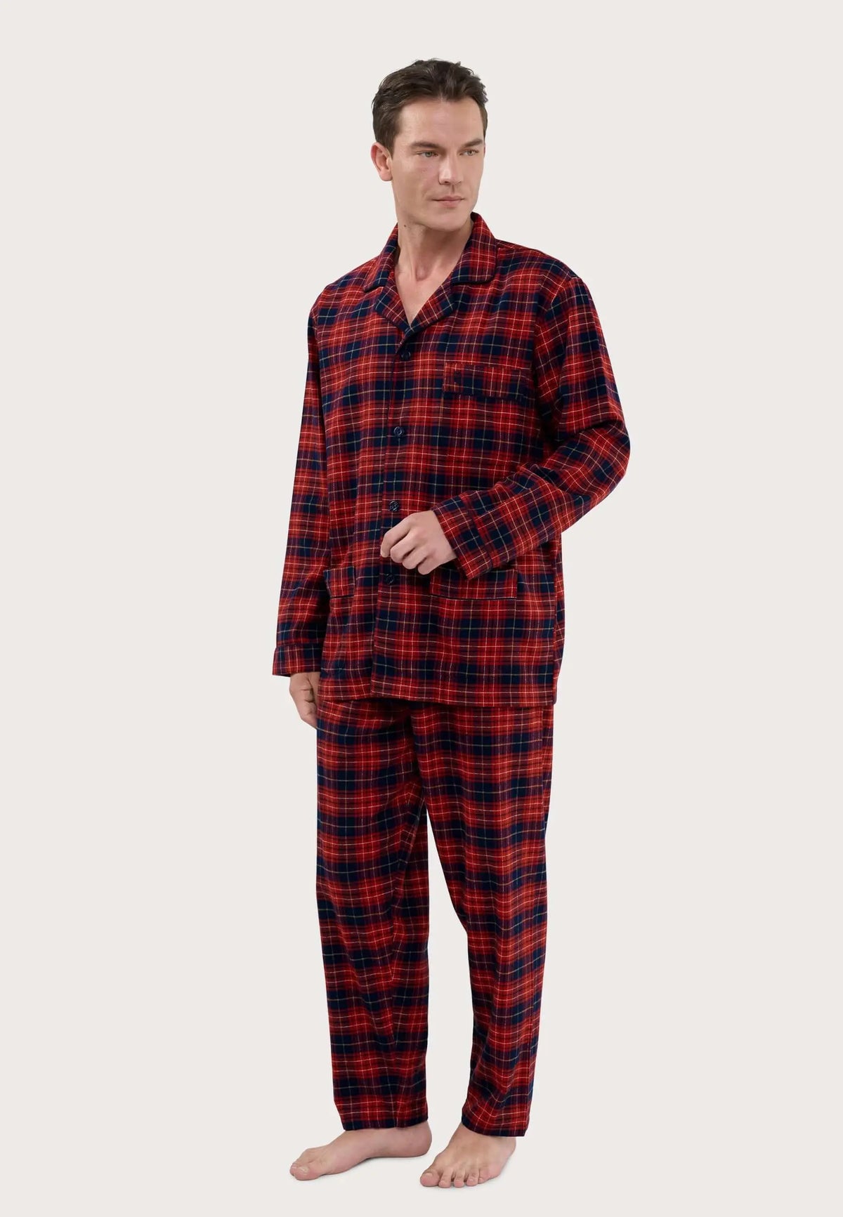 Pijama de hombre con estampado de cuadros rojos y azul marino, cuello solapa, botones y bolsillos en tejido suave.