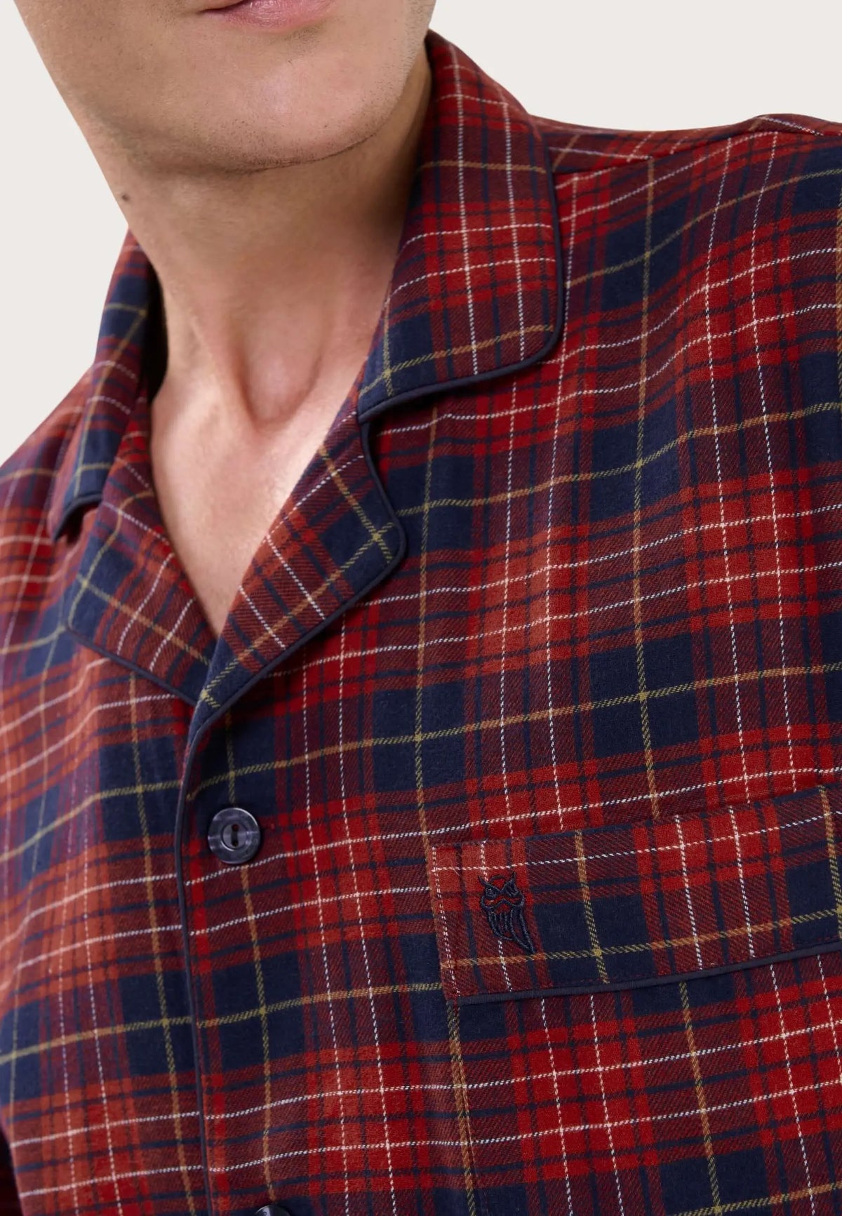 Pijama de hombre con cuello solapa y estampado de cuadros rojos y azul marino en tejido de franela suave.