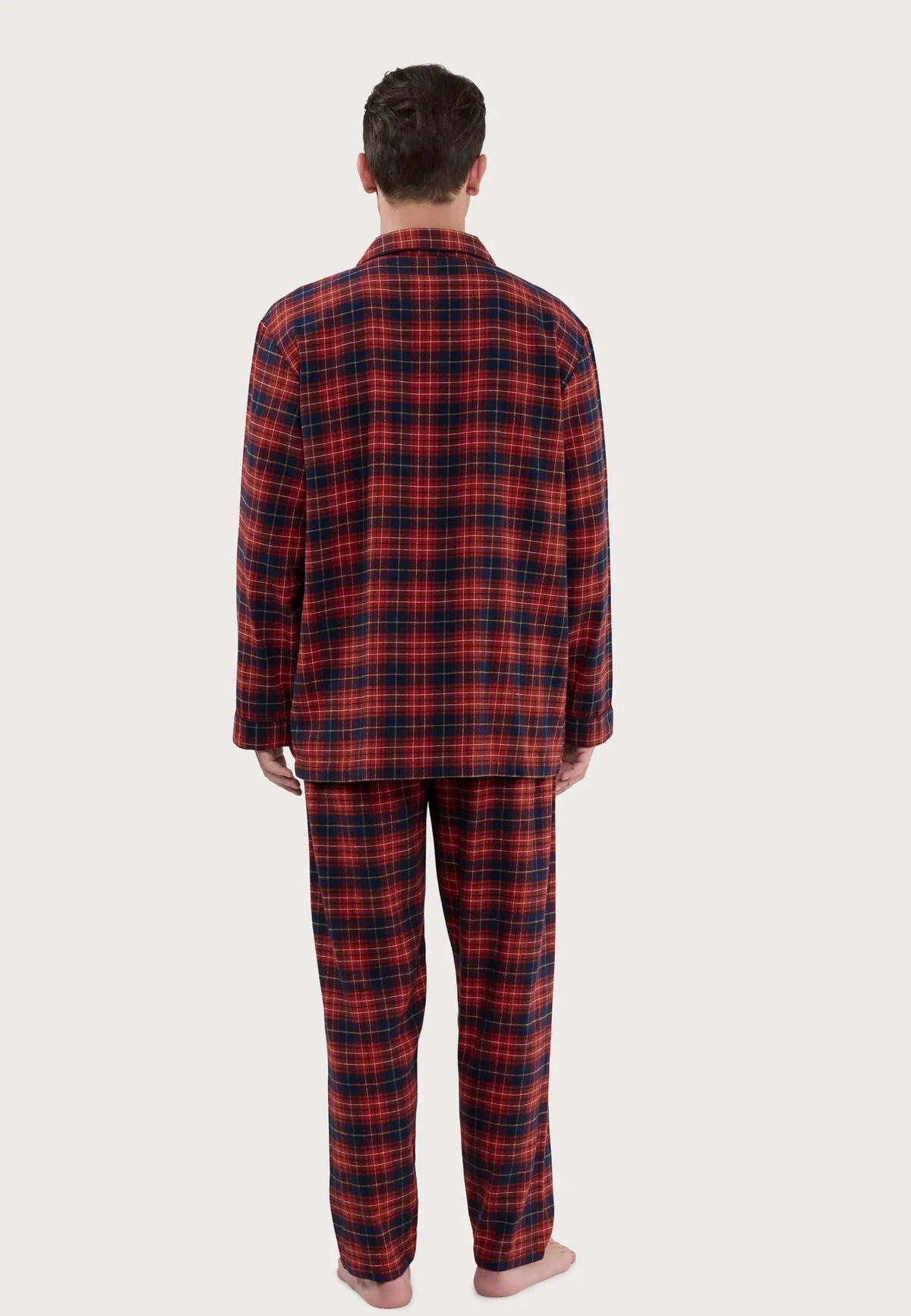 Pijama largo de hombre a cuadros rojos y azul marino, visto de espalda sobre modelo, con cuello de solapa.