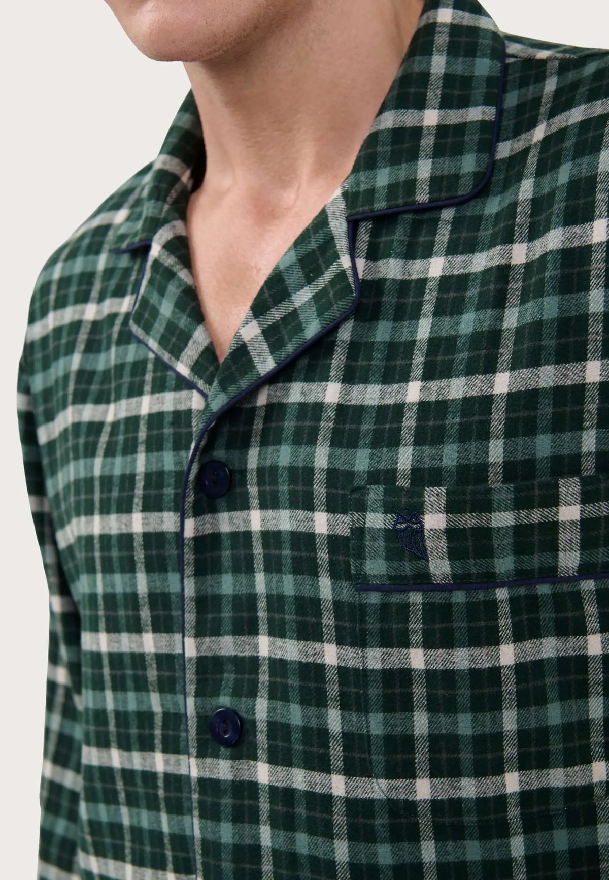 Pijama de hombre de cuadros verdes y blancos, tejido franela, cuello solapa, botones y bolsillo con logo bordado.