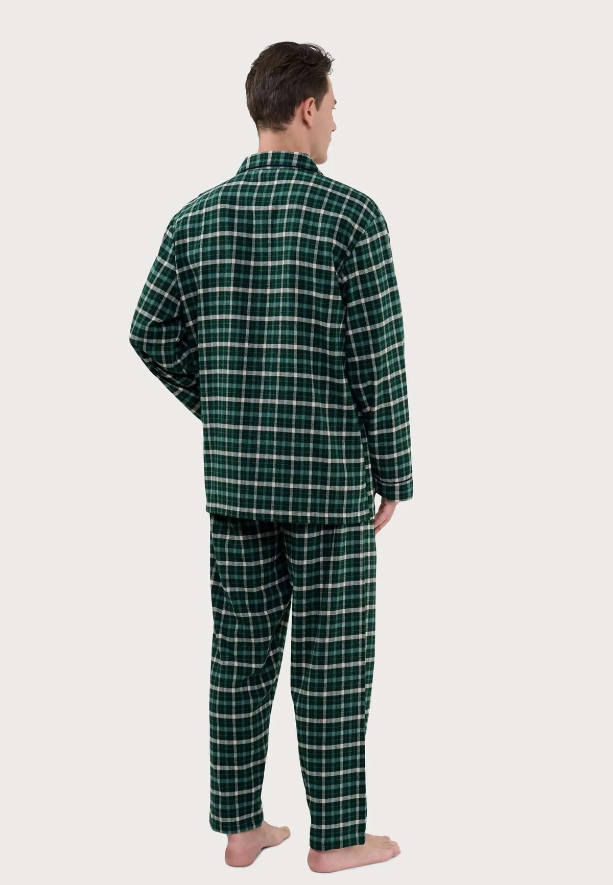 Hombre de espaldas vistiendo pijama largo de franela verde con estampado de cuadros y cuello de solapa.