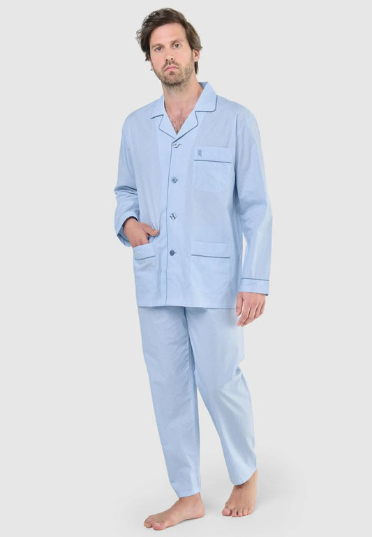 Hombre viste pijama largo de algodón celeste a rayas con solapa, botones, bolsillos y bordado en el pecho.