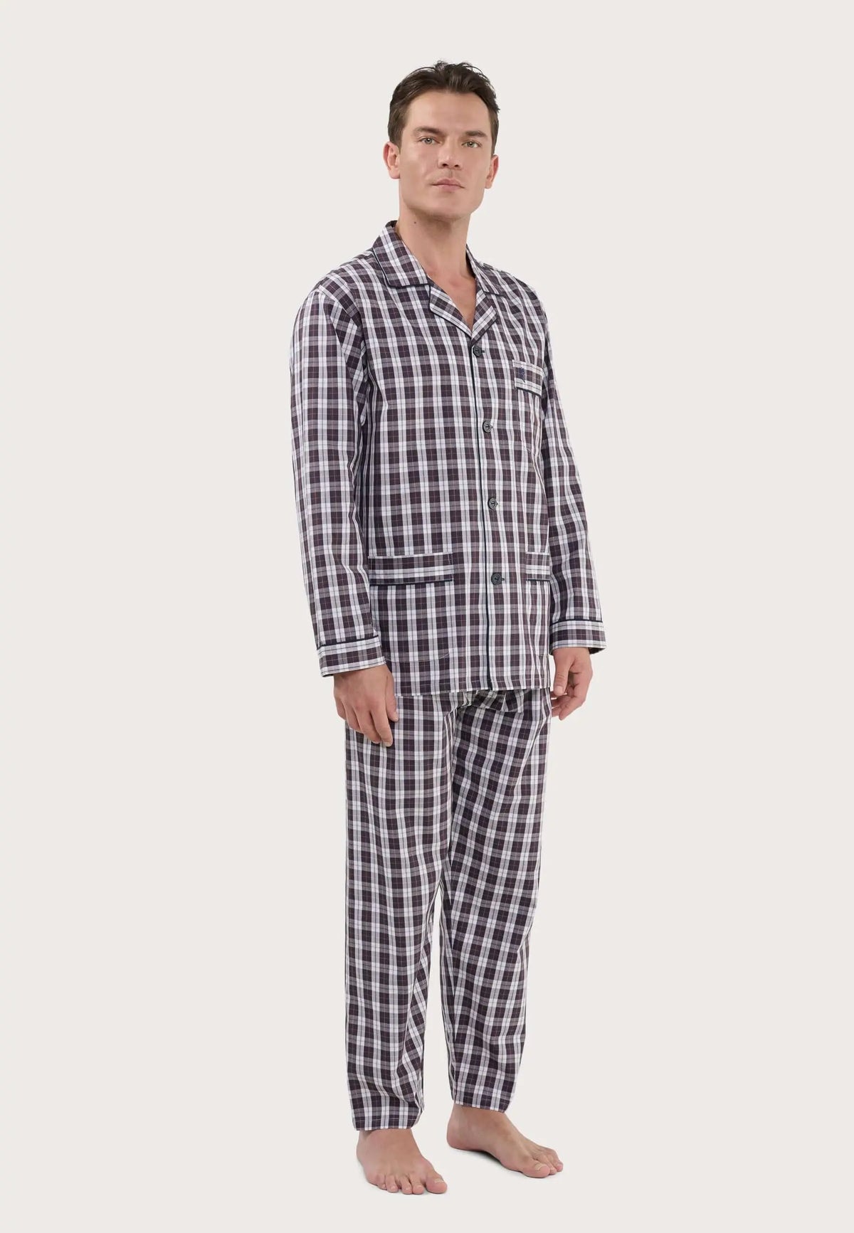 Pijama largo de hombre con estampado de cuadros en tonos rojos y blancos, camisa de solapa con botones y bolsillo.