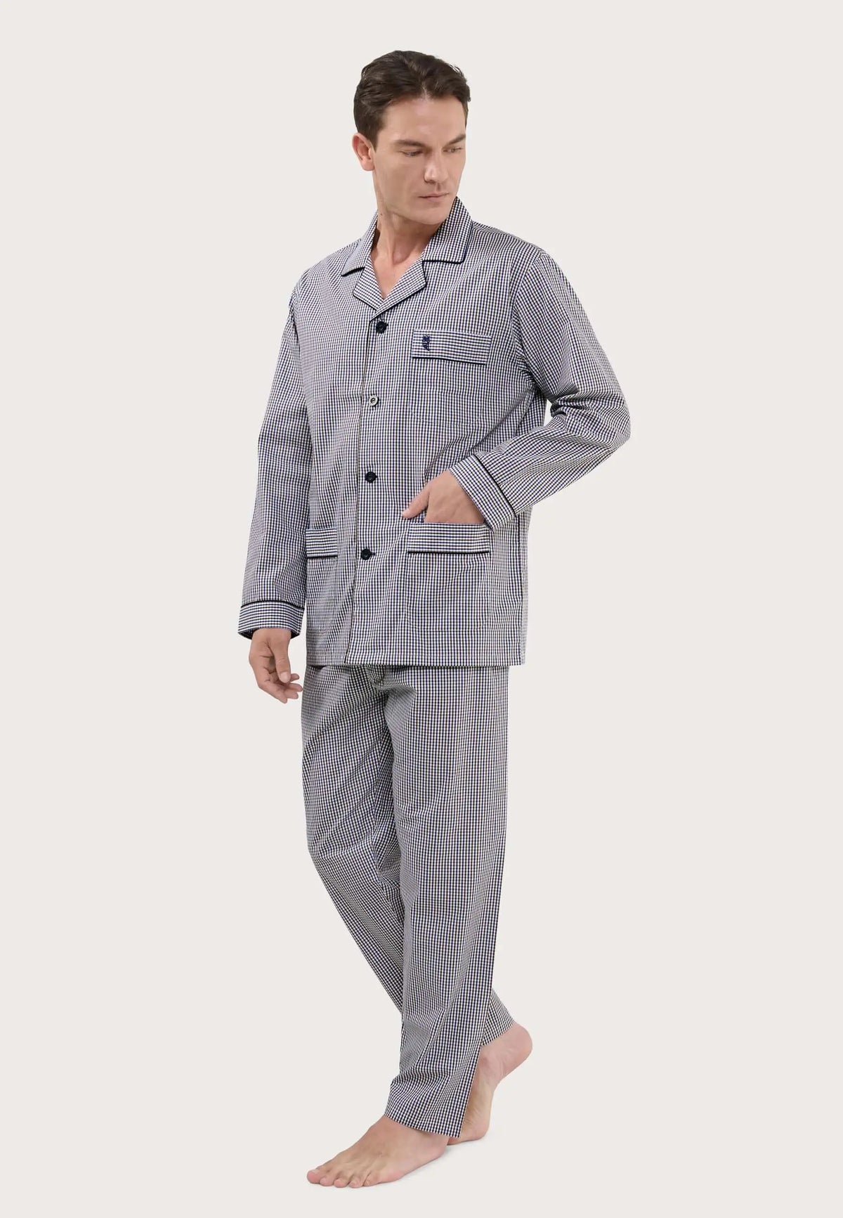Pijama largo de hombre con estampado de cuadros azul y blanco, solapa, botones y bolsillos, puesto por un modelo.