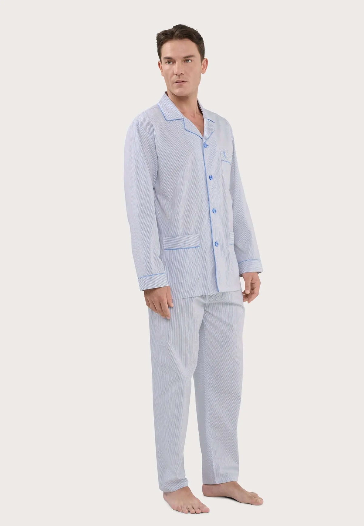 Pijama de hombre a rayas gris y beige con solapa, botones y ribetes azules, modelo de manga larga y pantalón largo.