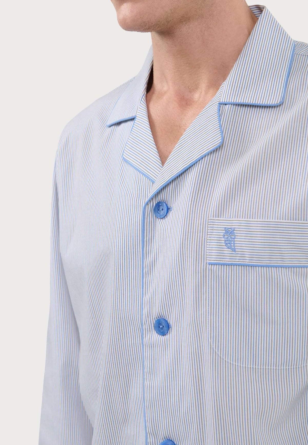 Pijama hombre a rayas azul y beige, cuello solapa, botones azules y bolsillo con bordado de búho en el pecho.