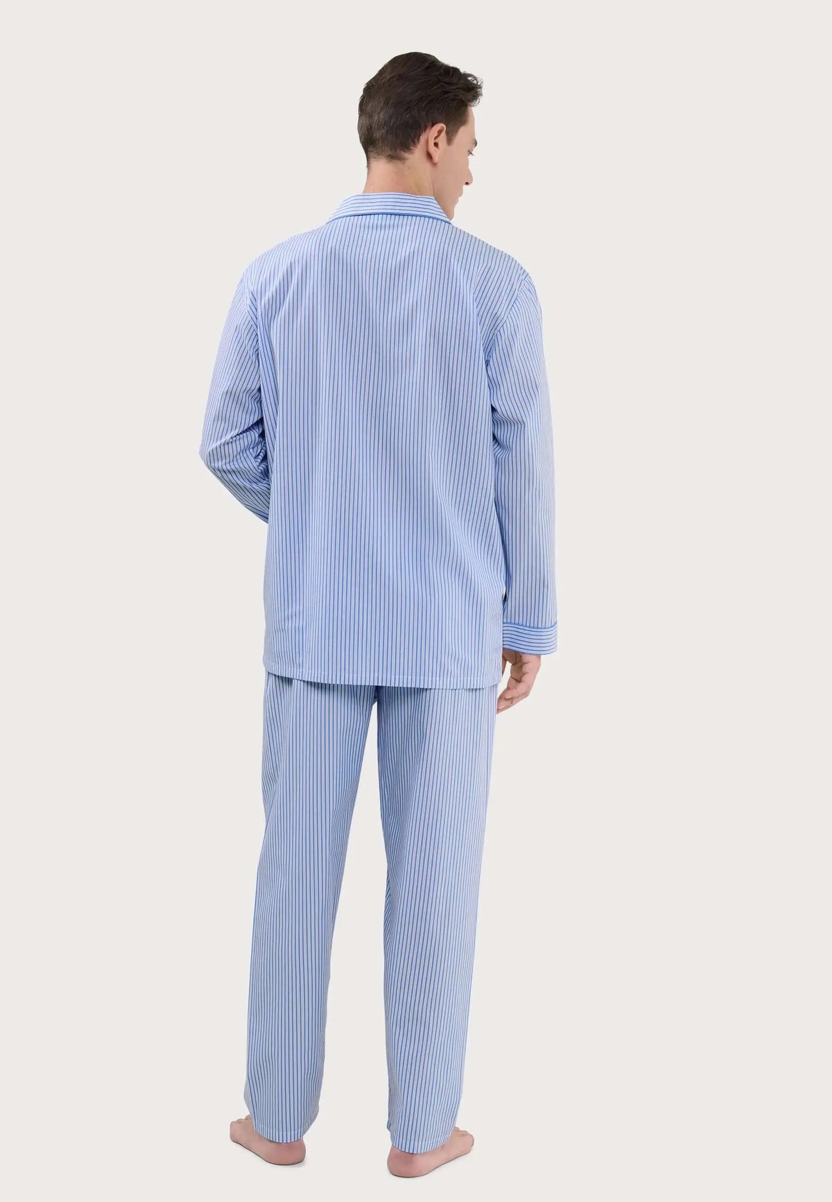 Pijama largo para hombre de rayas azules y blancas, con cuello solapa, visto de espaldas sobre fondo liso.