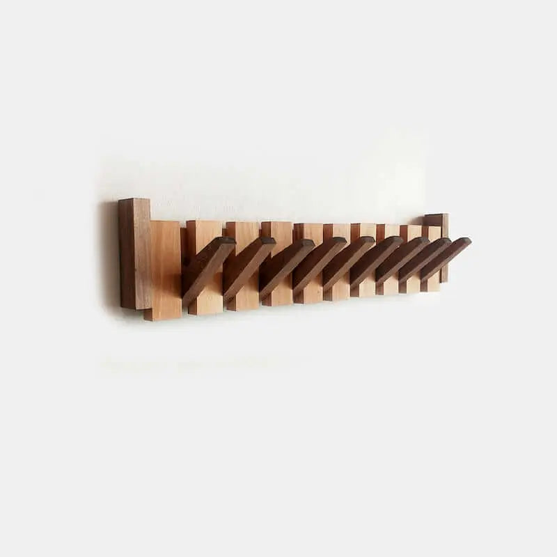 Perchero de pared estilo escandinavo, hecho de madera clara y oscura, con varios ganchos plegables en tono café.