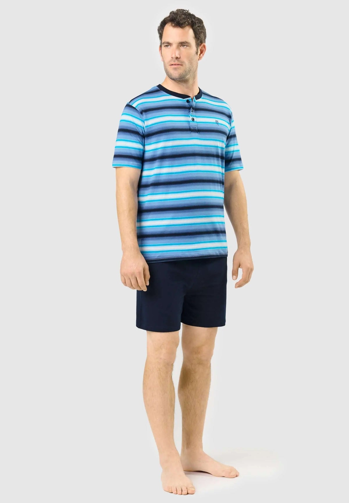 Pijama corto para hombre: camiseta de rayas azules con tapeta de botones y pantalón corto azul marino liso de algodón.