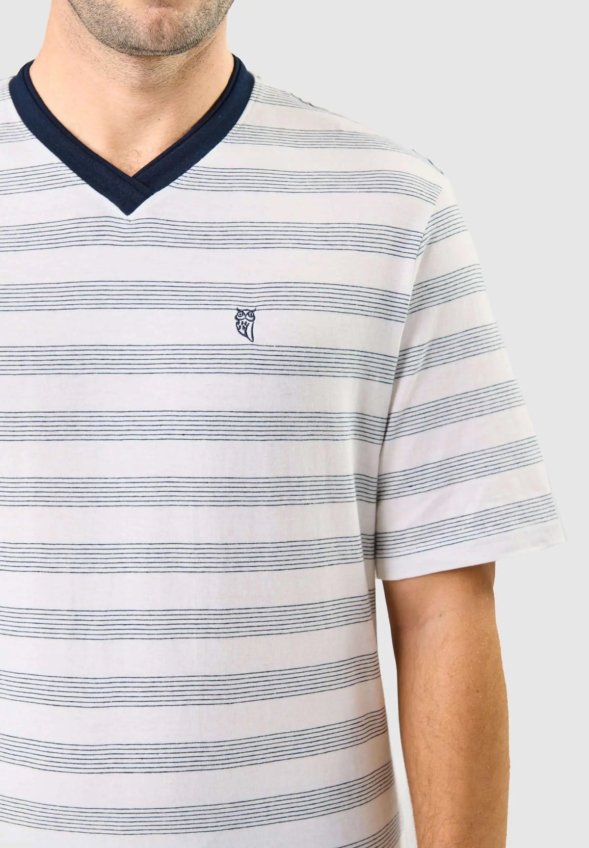 Camiseta de pijama hombre, rayas azules sobre fondo blanco, cuello pico marino y logo de búho, tejido punto algodón.