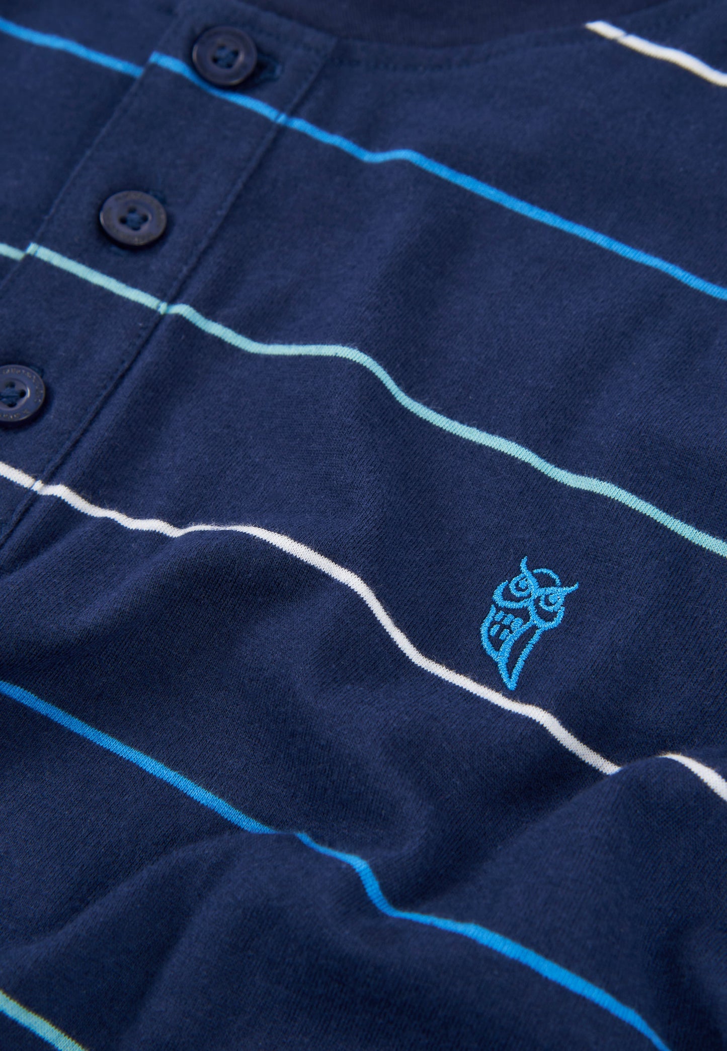 Camisa de rayas azul marino con botones y logo azul, de algodón suave y estilo casual.