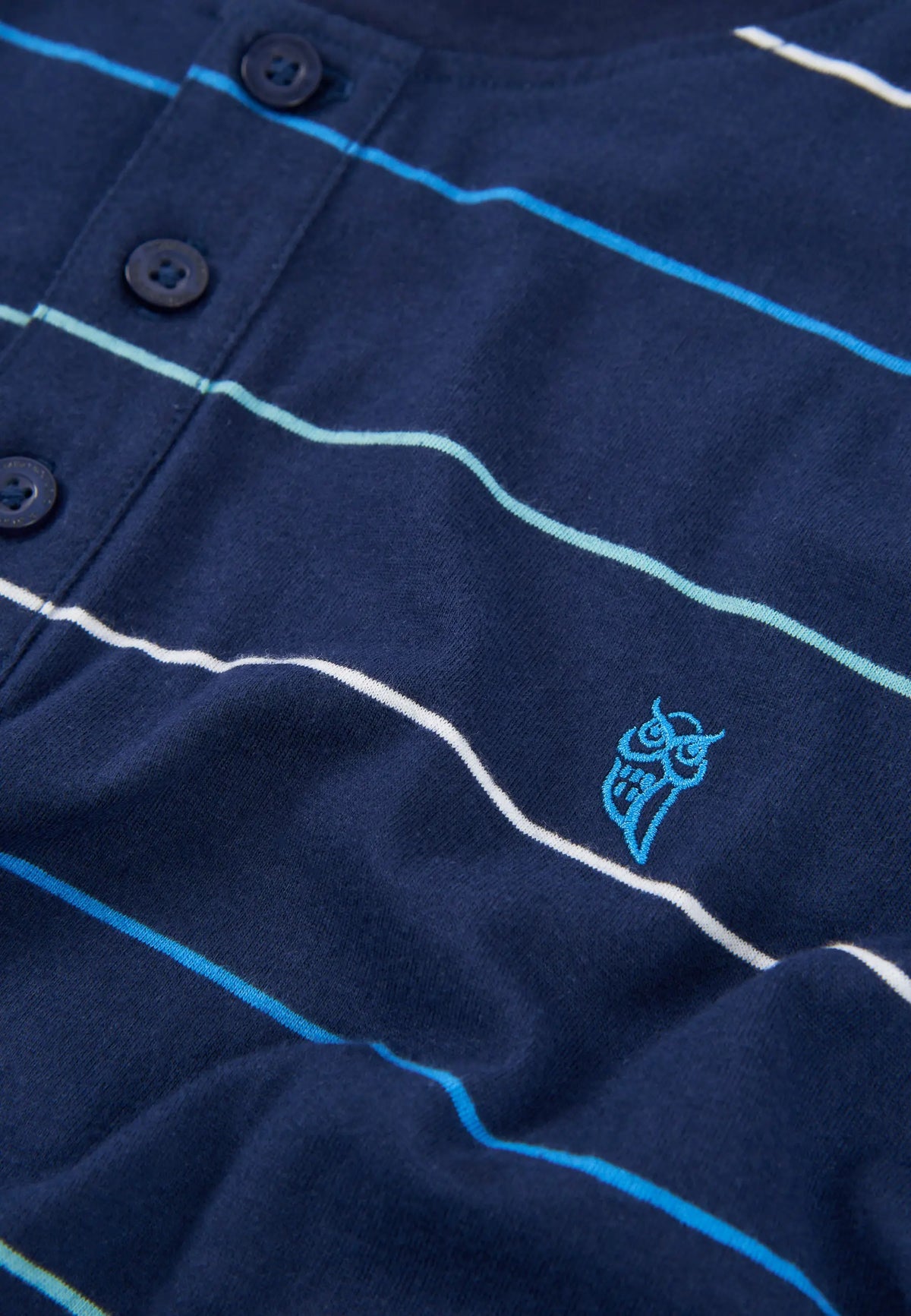 Camisa de rayas azul marino con botones y logo azul, de algodón suave y estilo casual.