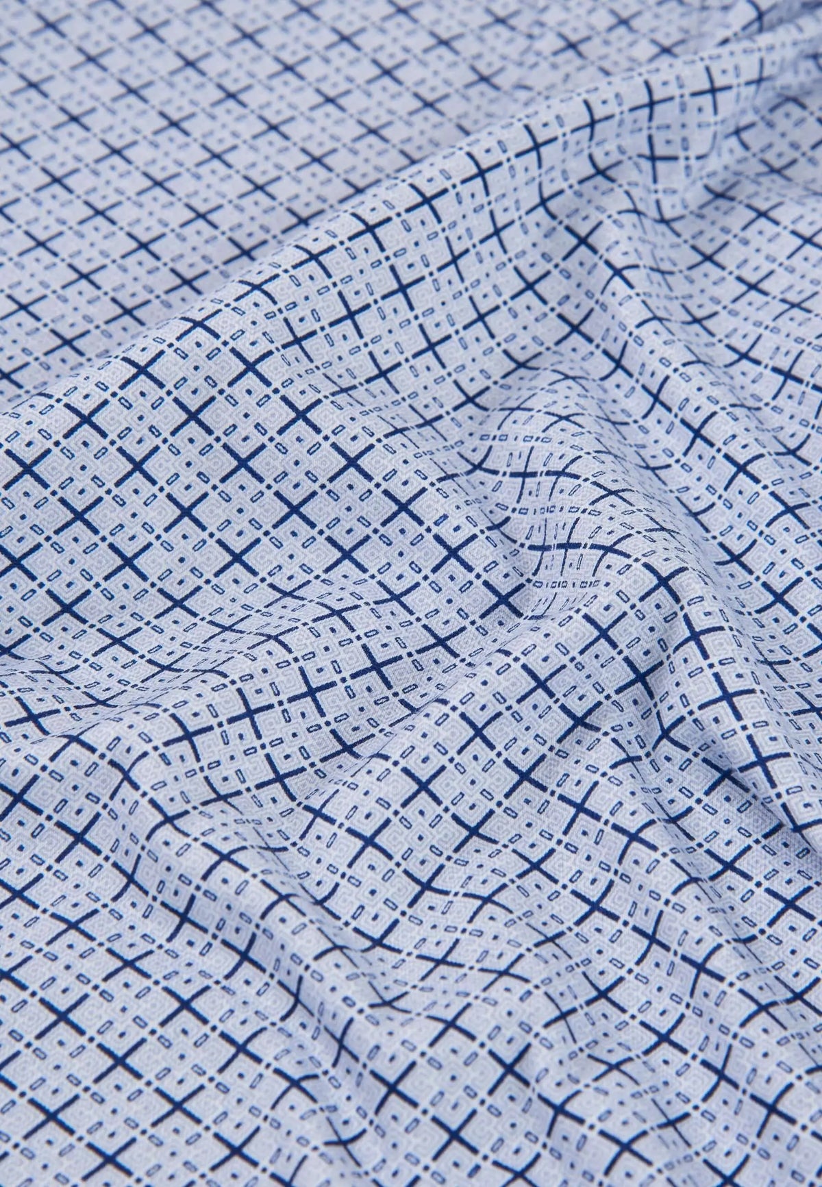 Tejido de algodón para pijama de hombre con estampado geométrico de cruces azules sobre fondo blanco, tacto suave.