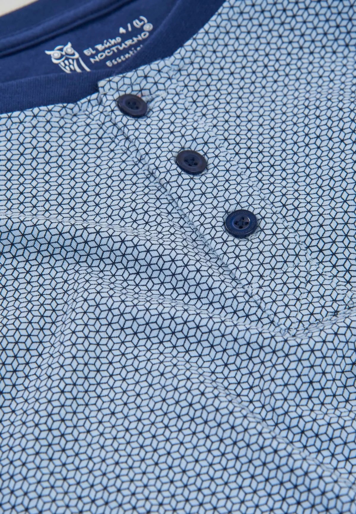 Detalle de pijama de verano para hombre en punto de algodón azul con estampado geométrico y tapeta de botones.