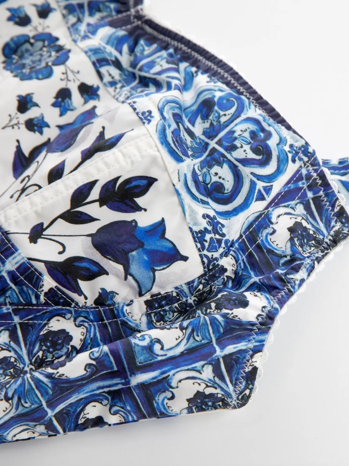 Cotton crop top with blue and white Italian Majolica tile and floral print, featuring stitched, structured cup panels.