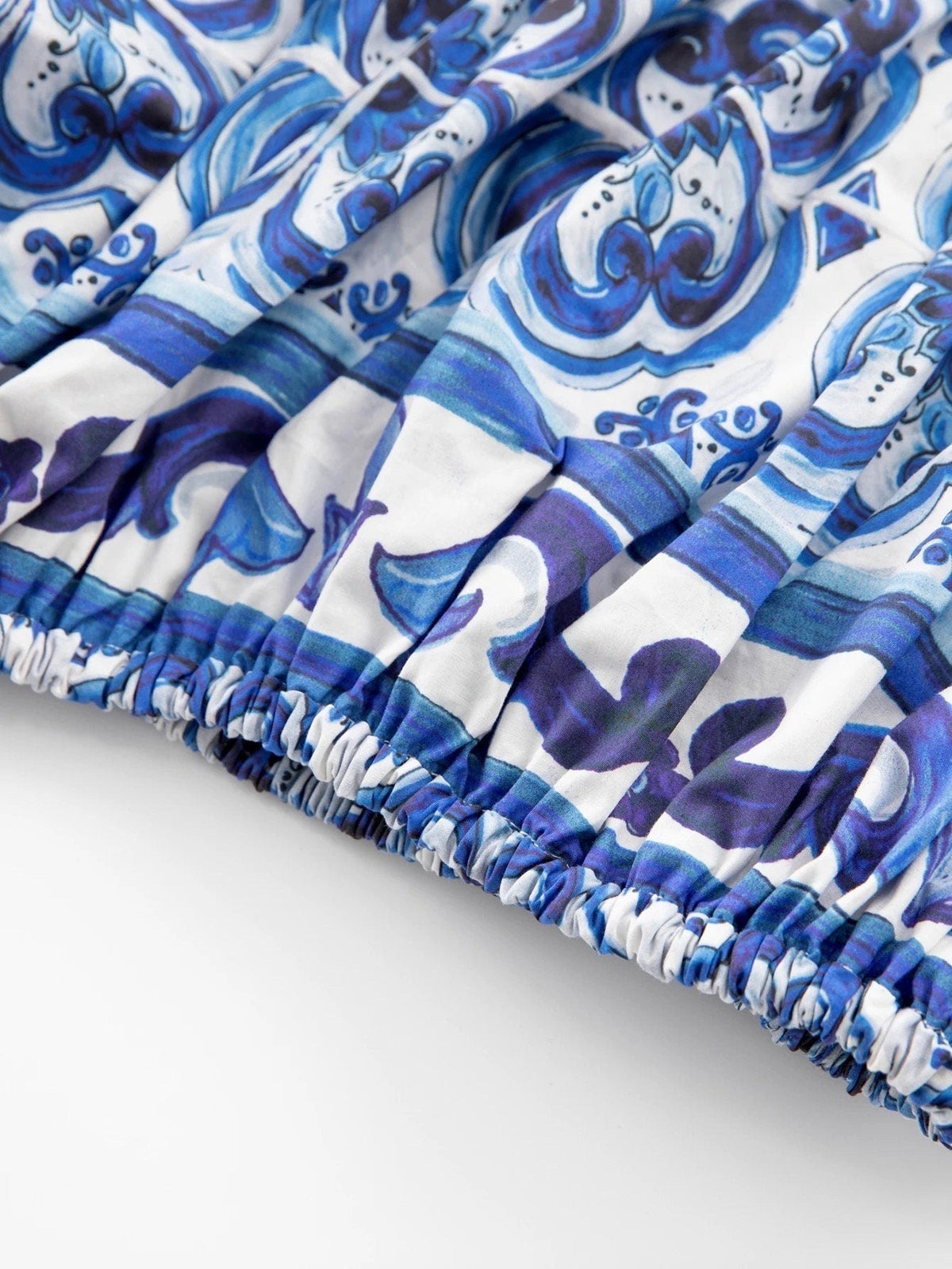 Blue and white floral-patterned pleated dress with elastic waistband in lightweight fabric. Perfect for summer outings.