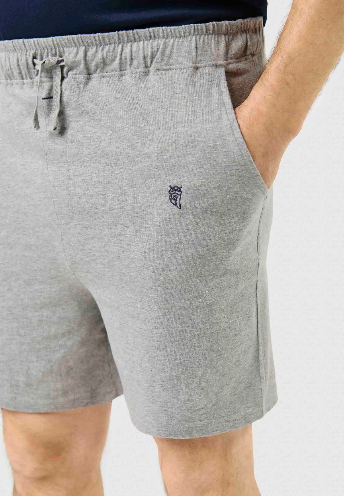 Pantalón corto de pijama para hombre en punto gris, estilo cómodo con cintura elástica, cordón ajustable y bolsillos.