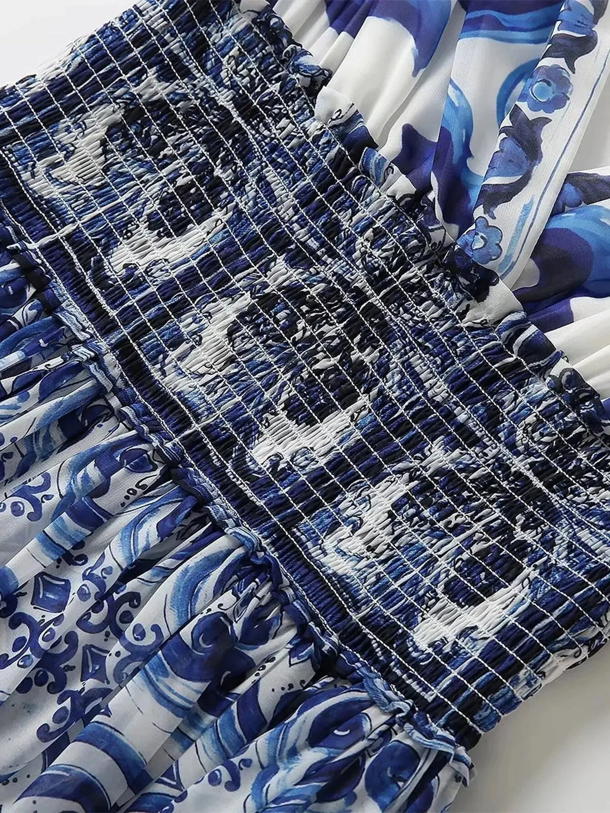 Blue and white floral patterned smocked dress with a feminine design, perfect for summer outings.
