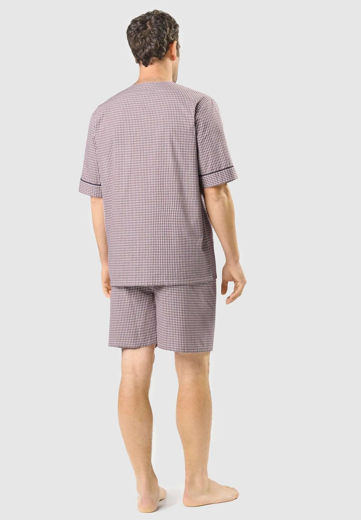Pijama de hombre corto, manga corta, estampado de cuadros rojos y blancos, con ribete oscuro en las mangas. Vista trasera.