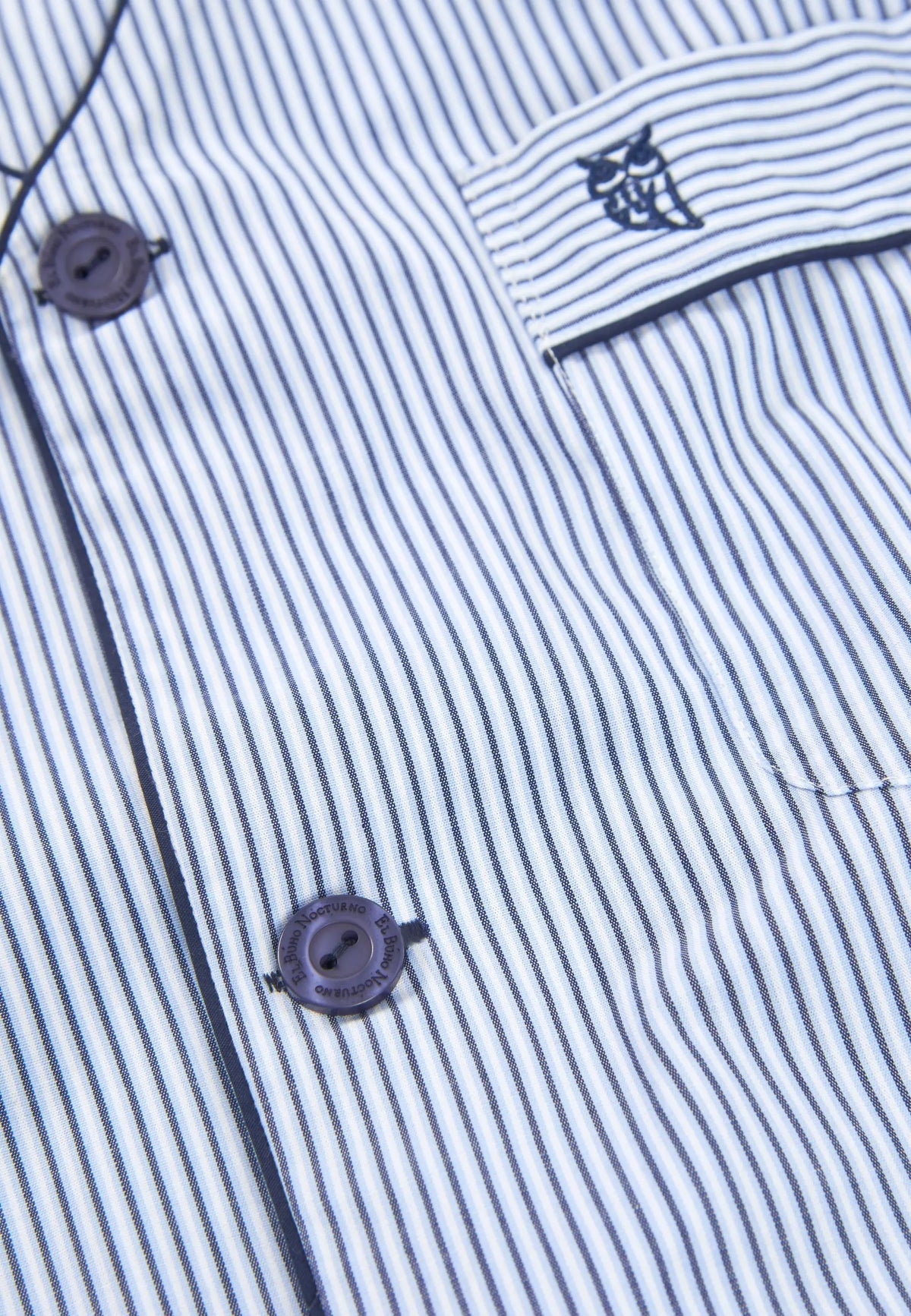 Camisa de algodón azul y blanca con rayas, botones oscuros y bolsillo con logo bordado. Ideal para un estilo casual.